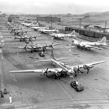 Black and White historical photo of Boeing Plant 2. Photo shows more than a dozen aircraft lined up at airport facility.