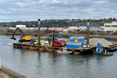 Photo of barges on the waterway with clean material and equipment mounted on top. Equipment is placing clean material at SMA 12B.
